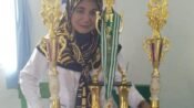 Kepala MI Al-Jannah Cihampelas KBB, Rini Resmiati, S.Pd.I., M.M bangga memperlihatkan sejumlah piala prestasi siswanya. (Dadan Saepudin/Mediaseruni)