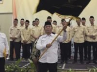 Ketua AMKI Karawang Endang Suryana alias Bah Nuvo mengibarkan pataka saat pelantikan. (Sarmin/Mediaseruni)