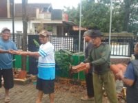 Linmas Jomin Timur lakukan kerja bakti di halaman Desa Jomin Timur, mereka terlihat semangat dan kompak. (Asep Suherman/Mediaseruni)