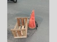 Warga berinisiatif menandai lubang menganga di ruas Jalan Nasional Sukabumi perlintasan Desa Cicurug dengan peti kayu. (Nyimas Irma/Mediaseruni)