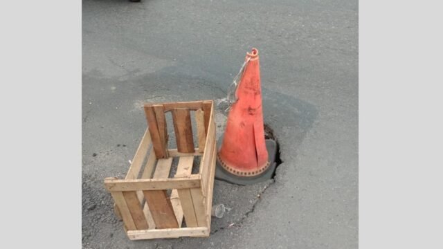 Warga berinisiatif menandai lubang menganga di ruas Jalan Nasional Sukabumi perlintasan Desa Cicurug dengan peti kayu. (Nyimas Irma/Mediaseruni)